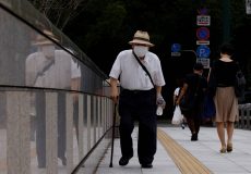 A man wearing a protective mask makes his way as the nation's capital, Tokyo, reported 31,878 cases of daily infections, surpassing the 30,000 mark for the first time amid the coronavirus disease (COVID-19) pandemic in Tokyo