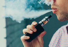 Close up on a man exhaling vapor from an electronic cigarette